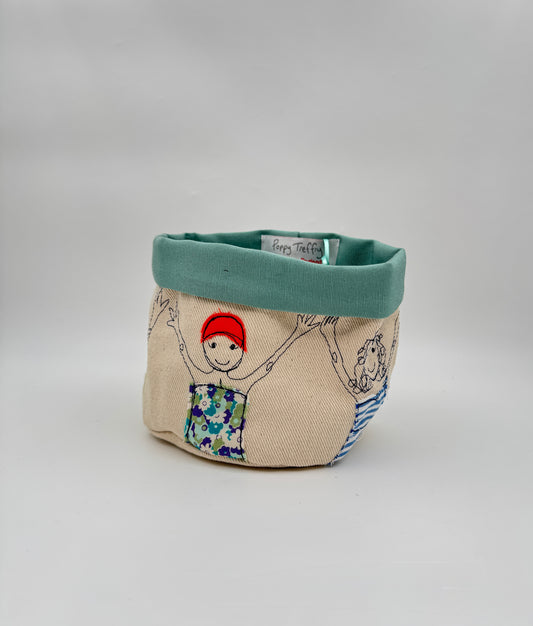 Charming fabric organizer featuring Poppy Treffry’s playful swimmers, perfect for bathroom, nursery, or craft storage.