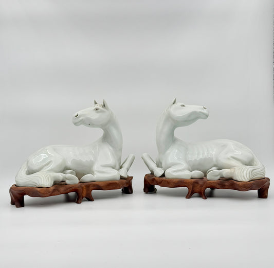 Pair of Chinese Blanc de Chine Porcelain Recumbent Horses on Carved Wood Stands